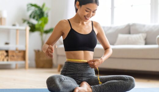 日本人女性が自宅でリラックスしながらウエストを測り、楽しくダイエットに取り組んでいる様子